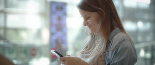 Woman Using Smartphone Indoors in Urban Setting