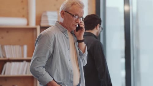 Senior Man Talking on Phone in Modern Office