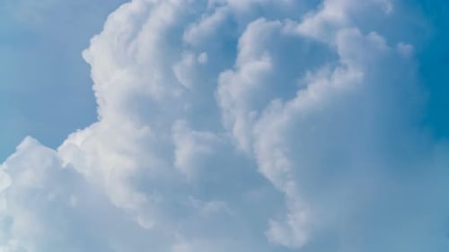 White Cumulus Clouds Slowly Moving Through Blue Sky