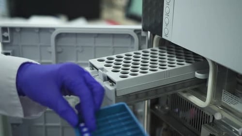 Technician Placing Sample Vials into Lab Machine