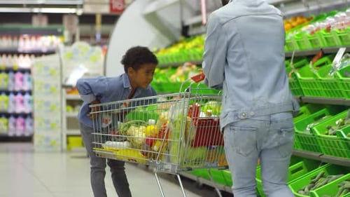Father and Son Playing while Shopping for Food