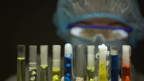 Chimiste vérifiant les sédiments dans le tube avec liquide jaune, substances émettant de la fumée