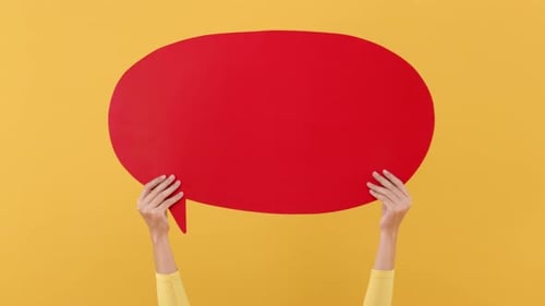 Manos de mujer sosteniendo burbuja de discurso roja