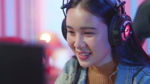 Smiling Woman Wearing Gaming Headset at Computer