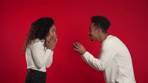 Young Couple. African Man Makes Marriage Proposal To His Lover Woman with Ring