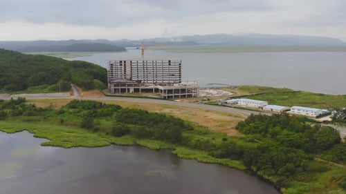 Vista con un Zumbido de un edificio de hormigón sin terminar en la orilla del mar