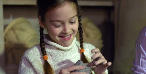 Girl Molding Clay with her Hands Indoors