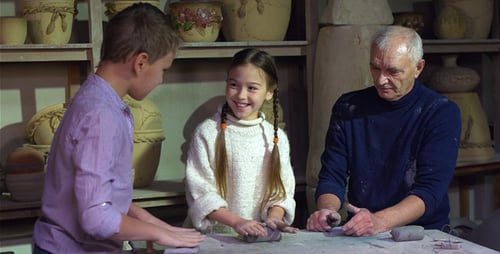 Man and Children Working with Clay in Studio
