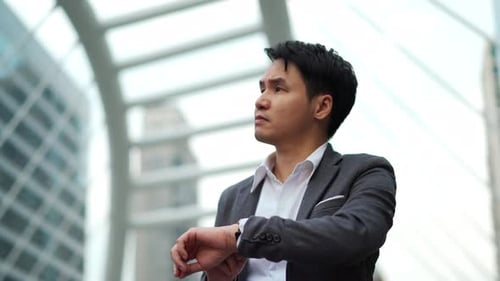 business man checking time on his watch in the city