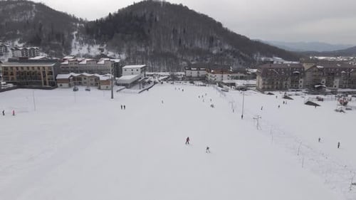 Luftaufnahme des Skigebiets mit verschneiten Berghängen und Winterbäumen.
