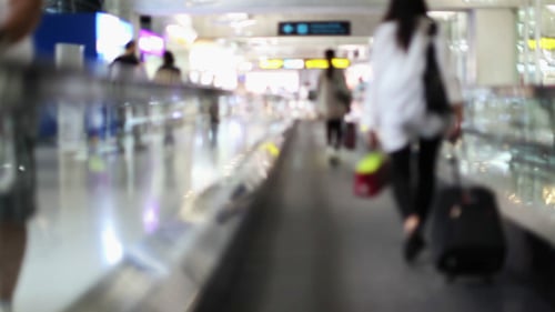 Blurred Airport Moving Walkway with Passengers