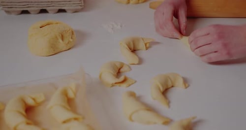 Woman Making Tasty Croissants on Table in Kitchen