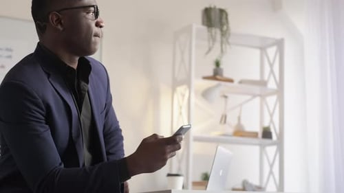 Man in Suit Using Phone in Modern Office