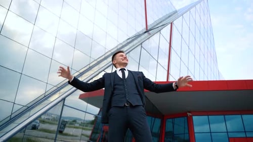 Businessman Celebrates Success in Front of Office Building