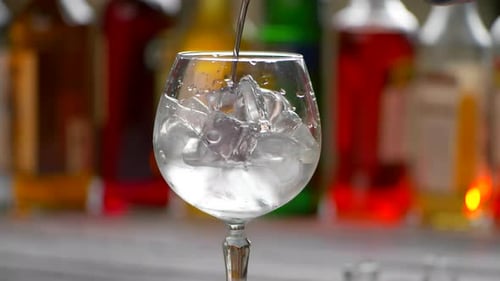 Liquor Poured into Glass with Ice Cubes