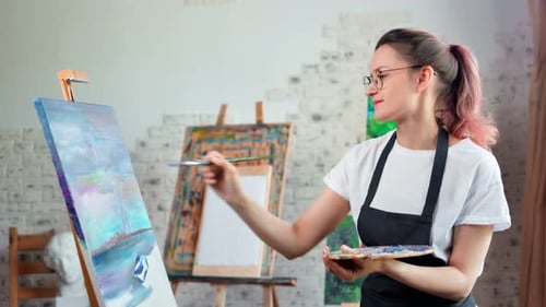 Happy Talented Young Woman Painter Enjoying Drawing Picture at Art Studio Medium Shot