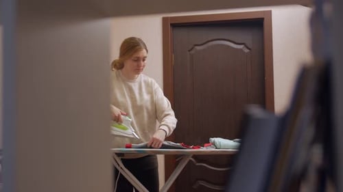 Woman Ironing Clothes on Ironing Board Indoors