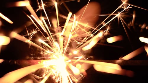 Sparkler Emits Golden Sparks in the Dark