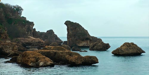 Rocky Shoreline with Calm Blue Sea on Overcast Day