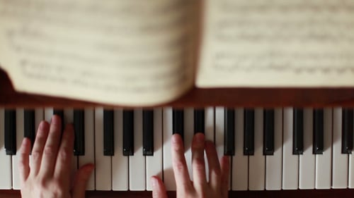 Top-Down View of Piano Keys Being Played
