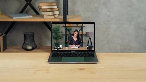 Laptop Displaying Woman Working at Her Desk