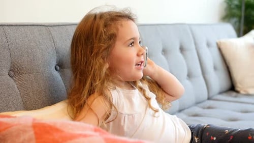 Girl Talking on Phone While Sitting on Sofa