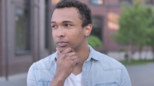 Young Man Thinking Outdoors in City Environment