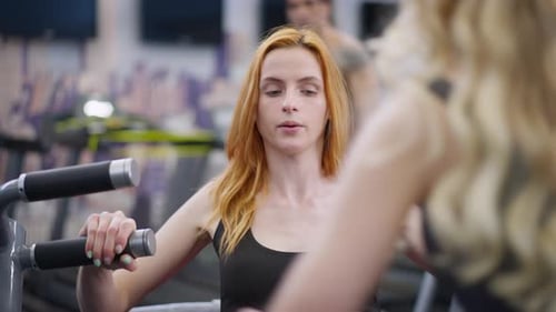 Woman Does Chest Press at Fitness Center