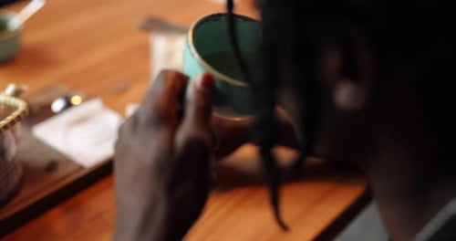 Afroamerikaner trinkt Tee im Café