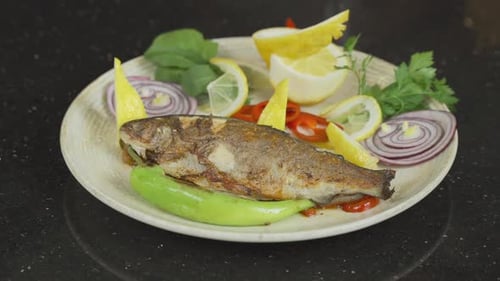 Cooked Fish Served with Vegetables and Lemon