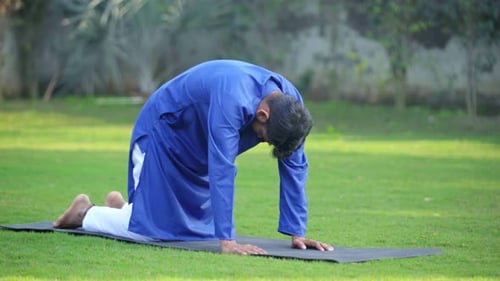 Young Adult Man Practicing Yoga in Nature