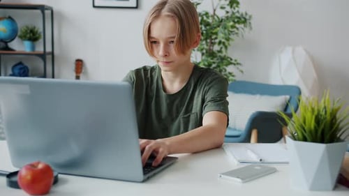 Zeitlupe eines Md Teenagers, der mit Laptop tippt und dann den Computer herunterfährt und aufgibt,