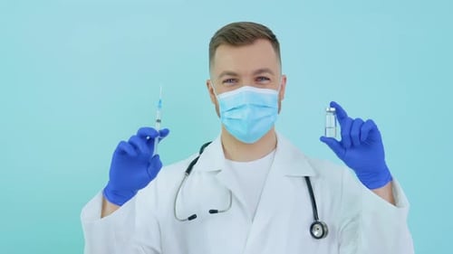 Medical Professional Holds Vaccine and Syringe