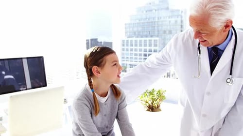 Doctor Talking to Little Girl in Medical Clinic