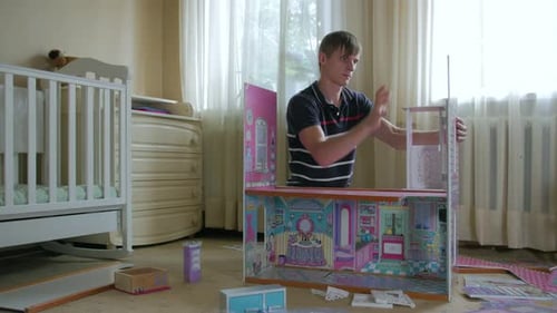 Young Adult Building Dollhouse in Bedroom