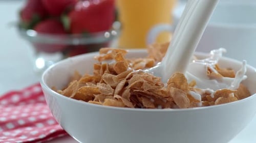 Milk is Poured into Cereal for Breakfast