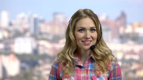 Hermosa operadora de centro de llamadas hablando con la cámara