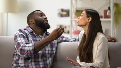 Couple Disagreeing During Difficult Conversation on Sofa