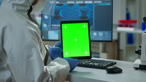 Chemist Man Wearing Protection Suit Holding Tablet with Green Mockup