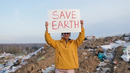 Woman Holds Save Earth Sign in Landfill
