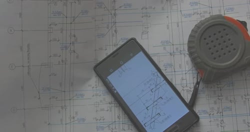 Marking Blueprint With Phone and Measuring Tape