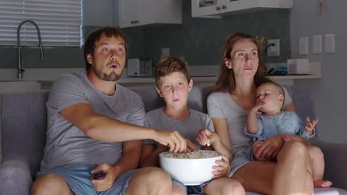 Family Watching Movie and Eating Popcorn on Couch