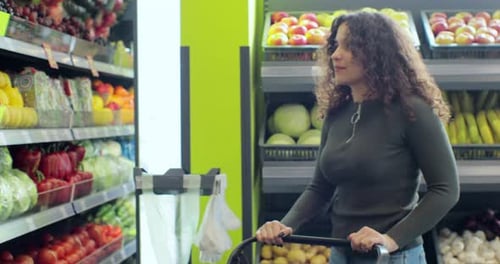 Young Woman Choosing Fruits at Supermarket and Putting Into Shopping Cart in Grocery Store