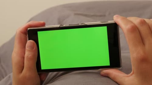 Woman changing pages on green screen smart phone using finger 4K 3840X2160 UltraHD footage - Female