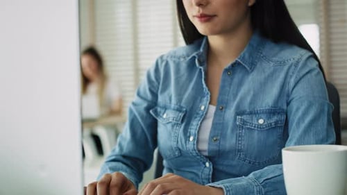 Woman Typing on Computer Keyboard in Modern Office