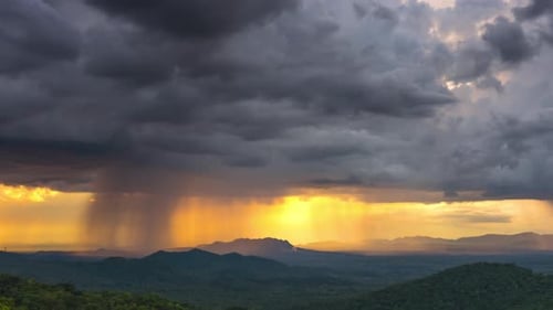 Dramatic Clouds and Rain at Sunrise Over Mountains