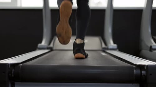 Nahaufnahme eines Mannes beim Joggen auf dem Laufband im Fitnessstudio Zeitlupe