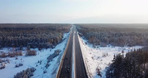 Luftaufnahme einer Autobahnstraße mit Verkehrsautos und Lastwagen auf der Straße im Winter