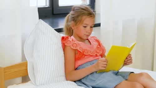 Happy Little Girl Reading Book at Home