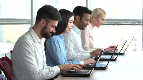 People Sitting in Office and Working on Laptops.